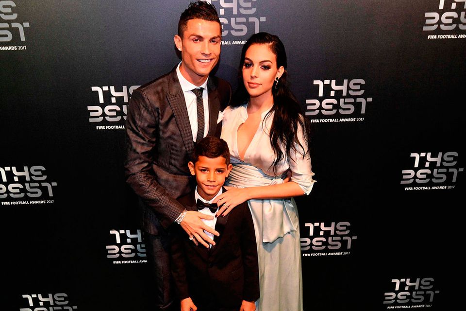 Real Madrid and Portugal forward Cristiano Ronaldo (L) poses for a photograph with partner Georgina Rodriguez (R) and his son Cristiano Ronaldo Jr as he arrives for The Best FIFA Football Awards ceremony, on October 23, 2017 in London. / AFP PHOTO / Glyn KIRKGLYN KIRK/AFP/Getty Images