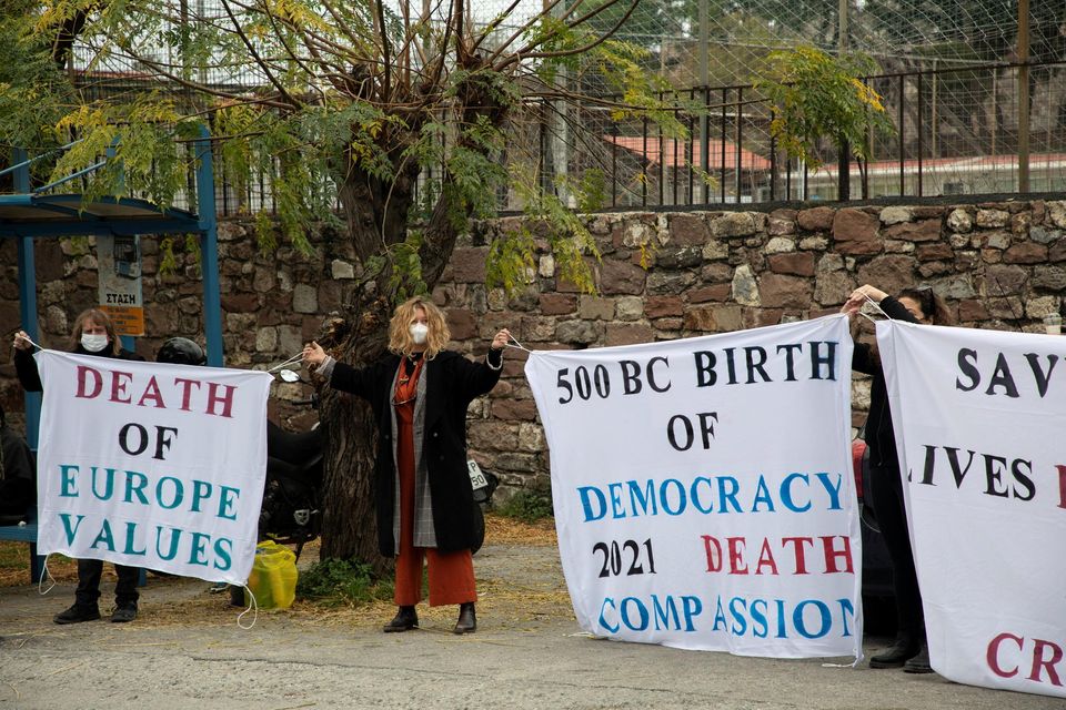 Supporters of aid workers who face trial over refugee rescues, hold banners outside a courthouse on the island of Lesbos, Greece. Reuters