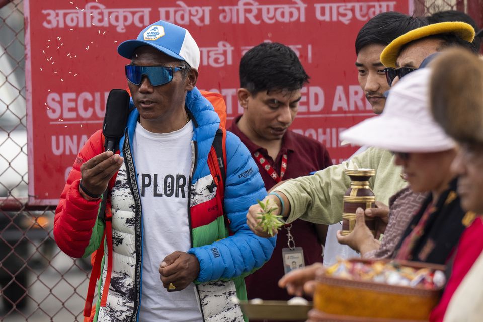 Renowned Sherpa mountain guide Kami Rita, left, returning from Mount Everest after his record 30th successful ascent, arrives at the airport in Kathmandu, Nepal, on Friday (Niranjan Shrestha/AP)