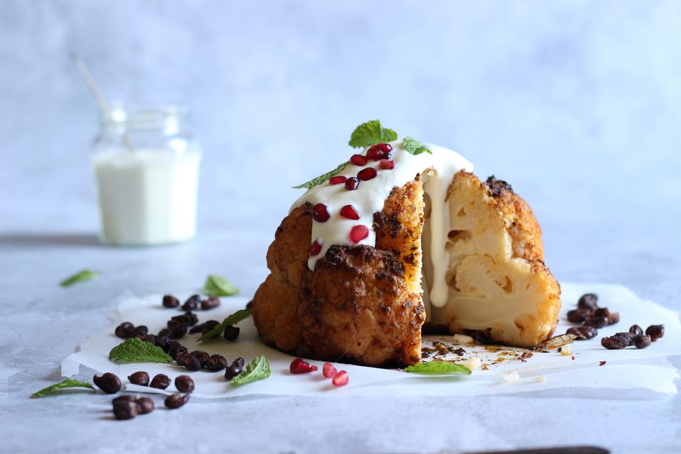 "This recipe feels perfect as is, but feel free to serve alongside a simple bowl of baby potatoes and a sharp garden salad." Whole roasted cauliflower with black beans & lime yoghurt. Photo: Susan Jane White