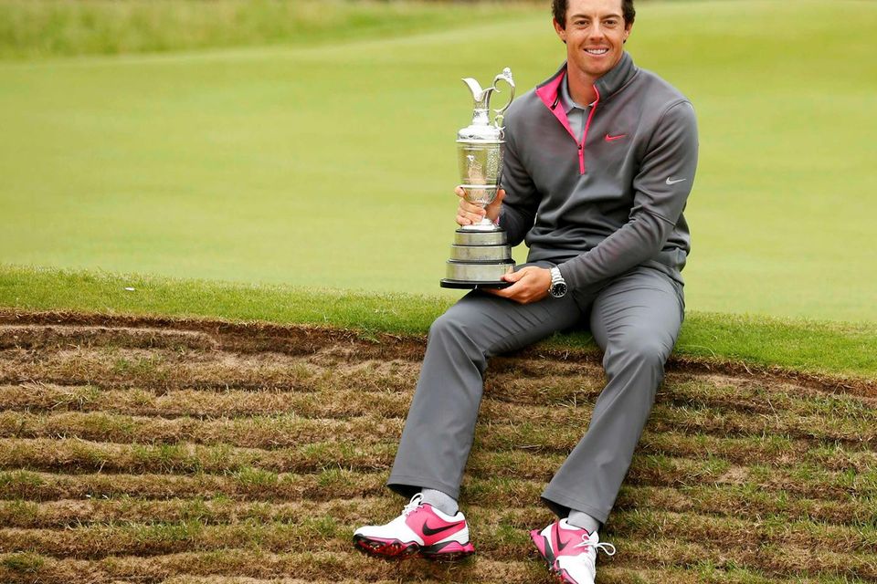 Rory McIlroy sits on the edge of a bunker as he holds the Claret Jug after winning the British Open Championship