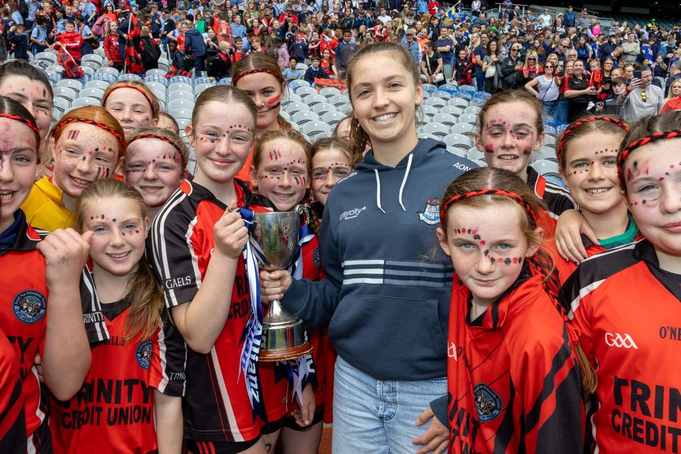 Corn Matt Griffin: Holy Trinity SNS, Donaghmede v St Mochta’s NS, Clonsilla. Kate McLoughlin receives the cup from Dublin Camogie Aisling O Neill.