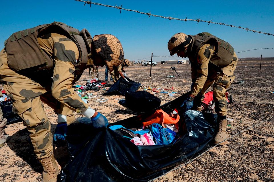 Egyptian soldiers collect personal belongings of plane crash victims at the crash site in the Sinai Peninsula. Photo: AP