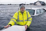 thumbnail: Liam Kehoe waist deep in water with his new house flooded in the backround at Caherlea, near Claregalway, Co Galway, yesterday
