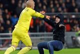thumbnail: A pitch invader clashes with Sevilla's Marko Dmitrovic. Photo: Reuters
