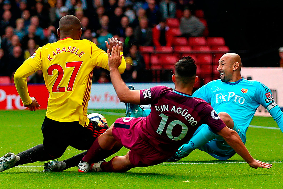 Sergio Aguero squeezes his third goal of the afternoon past Watford goalkeeper Heurelho Gomes at Vicarage Road. Photo: PA Wire