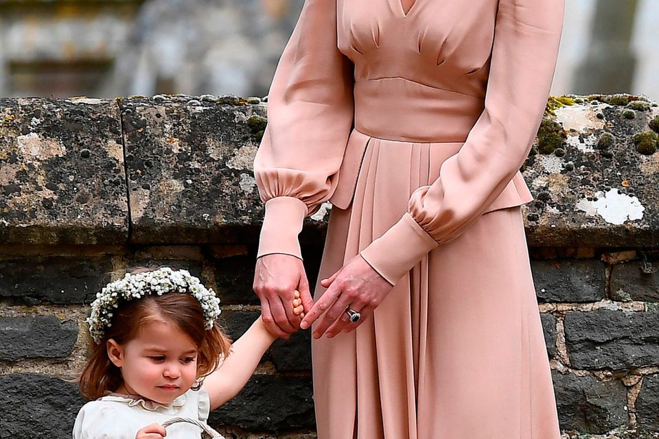 The Duchess of Cambridge with her daughter Princess Charlotte outside St Mark's church in Englefield, Berkshire, following the wedding of Pippa Middleton and James Matthews.