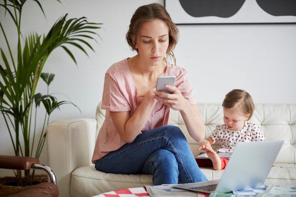 Parent on phone ignoring child. Picture posed