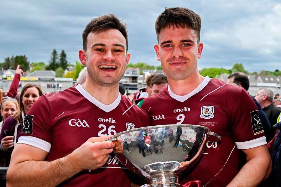 Galway players Cillian McDaid, left, and Seán Kelly with the trophy after their side's victory in the Connacht SFC final against Mayo at Pearse Stadium in Galway. Photo: Seb Daly/Sportsfile
