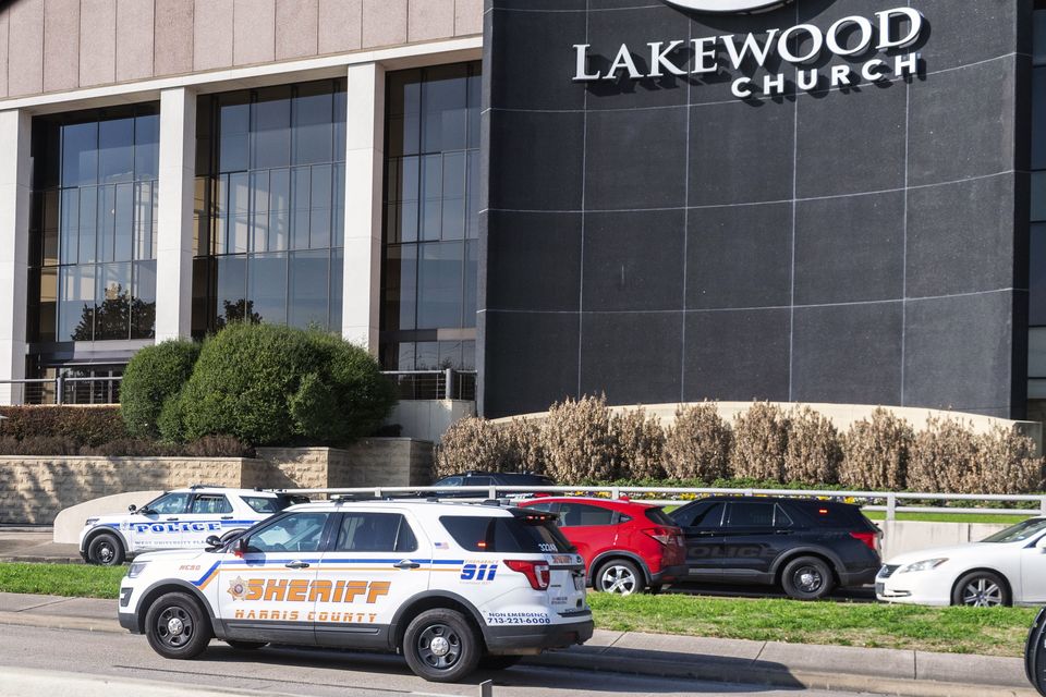 Emergency vehicles line the feeder road outside Lakewood Church following reports that a woman opened fire inside (Kirk Sides/Houston Chronicle via AP)
