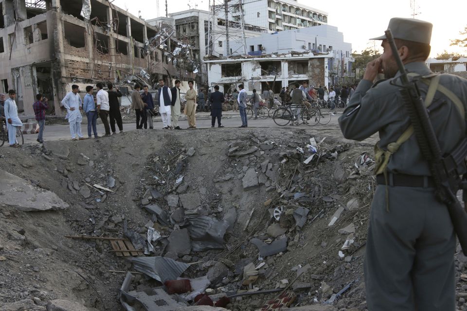 Security forces stand next to the crater created by the explosion in front of the German embassy (AP)