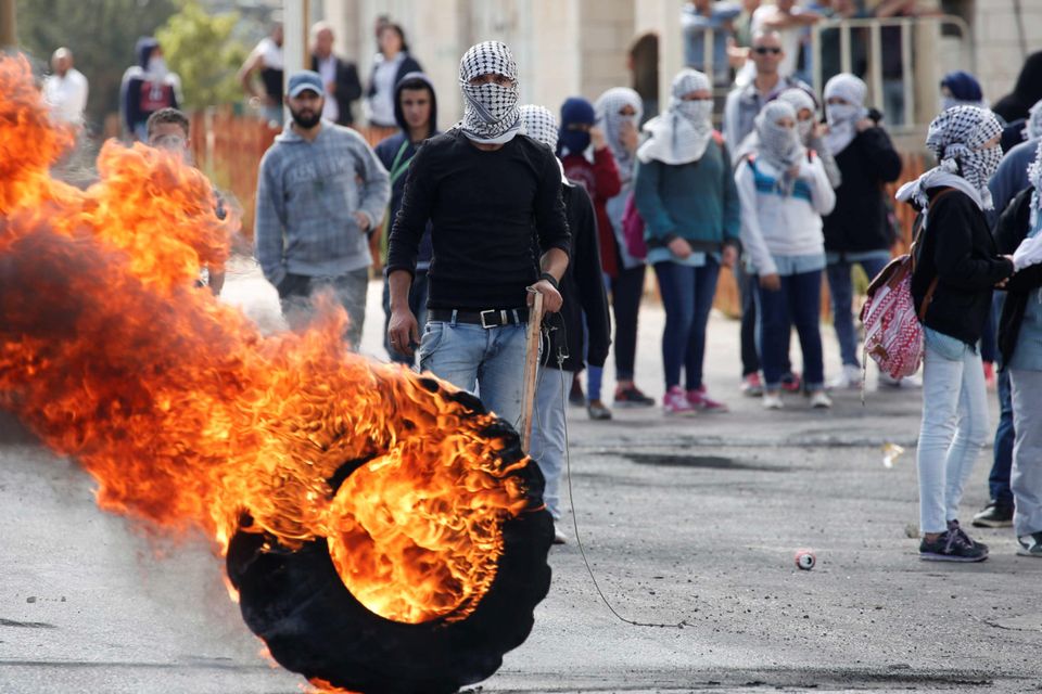 Palestinian stone throwers clash with Israeli security forces (unseen) in Beit El, near the West Bank city of Ramallah, on October 8, 2015.