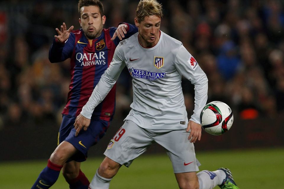 Atletico's Fernando Torres, right, fights for the ball against Barcelona's Jordi Alba during a Copa del Rey Quarterfinal match between FC Barcelona and Atletico Madrid