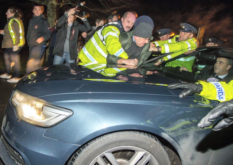 Gardai attempt to remove a water protester from the bonnet of the car carrying Taoiseach Enda Kenny after demonstrators surrounded him as he arrived at a function in Sligo last night. Photo: James Connolly.
