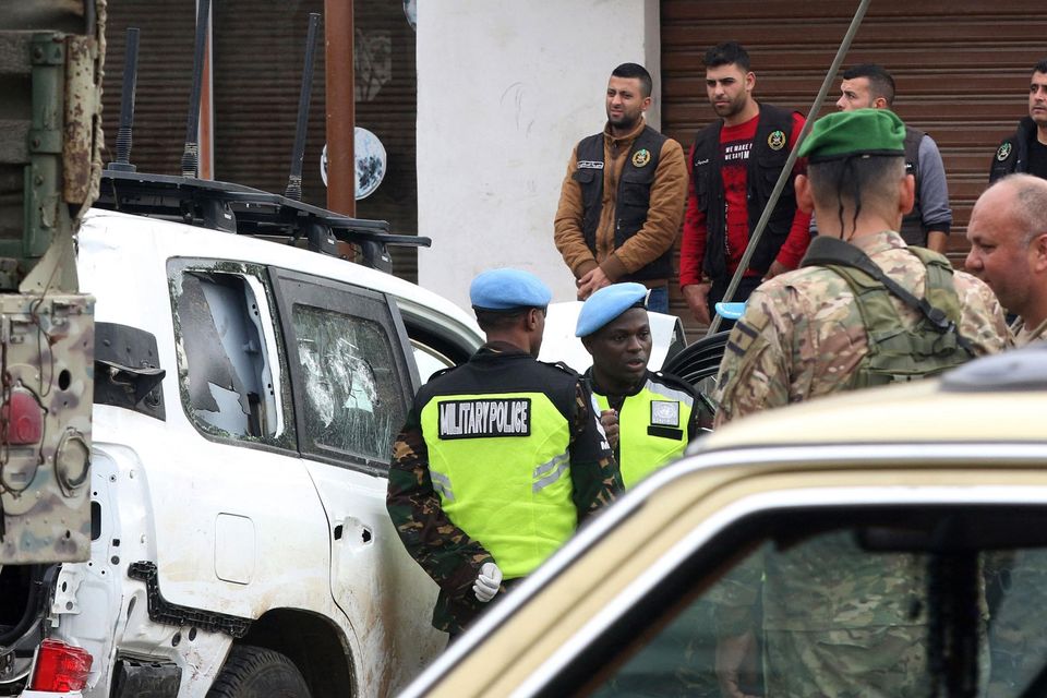 Members of the UN peacekeepers forces and Lebanese soldiers gather near a bullet-riddled car at the site where a UN peacekeeping force UNIFIL convoy came under small arms fire, in the village of Aqibya in south Lebanon, on December 15, 2022. - An Irish soldier of the UN peacekeeping force in south Lebanon near the Israeli border was killed and three wounded, Irish officials said. (Photo by Mahmoud ZAYYAT / AFP) (Photo by MAHMOUD ZAYYAT/AFP via Getty Images)