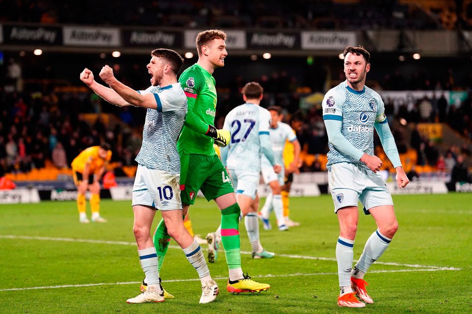 Bournemouth's Irish goalkeeper Mark Travers, centre, with Ryan Christie, left, and Adam Smith celebrate after the final whistle of the Premier League win over Wolves at Molineux