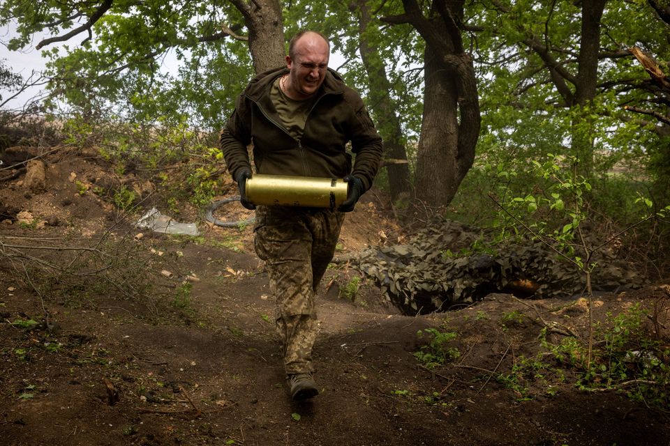 A member of Ukraine's 57th brigade carries an artillery shell at a position at the outskirts of Kupiansk. Photo: Reuters