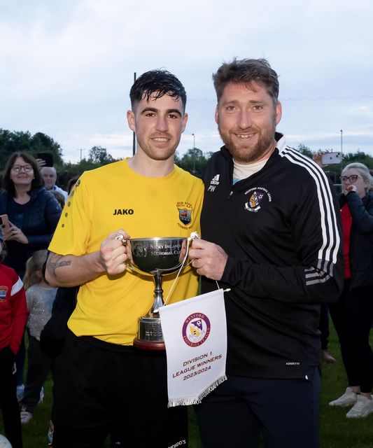 New Ross Celtic captain Seán Duffy receives the trophy from Pádraig Whitty.