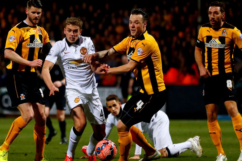 James Wilson of Manchester United battles for the ball with Josh Coulson of Cambridge United during the FA Cup Fourth Round match between Cambridge United and Manchester United