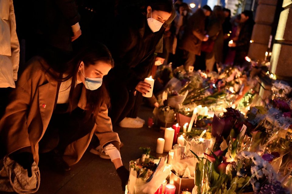 People place flowers and candles during a memorial for Ashling Murphy outside Government buildings, in Dublin. Photo: REUTERS/Clodagh Kilcoyne