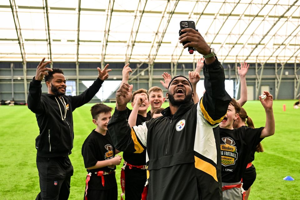 Pittsburgh Steelers legend Vince Williams takes a picture of himself and Will Allen with some of the children during the flag football clinics. Photo by Sam Barnes/Sportsfile