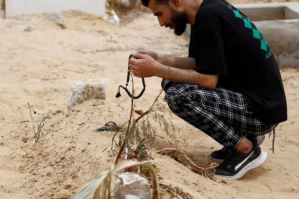 Rami al-Sheikh Jouda, an uncle of baby Sabreen al-Rouh, prays next to her grave in Rafah. Photo: Reuters