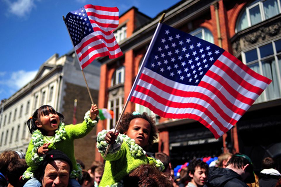 Children wave US flags as they queue to see President Obama. Photo: Getty Images