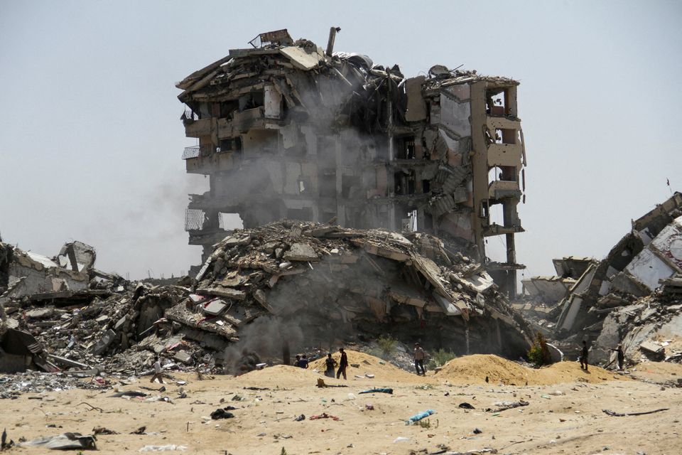Palestinians walk past the rubble of residential buildings destroyed by Israeli strikes, amid the ongoing conflict between Israel and Hamas, in the northern Gaza Strip, April 22, 2024. REUTERS/Mahmoud Issa     TPX IMAGES OF THE DAY     