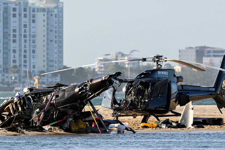 The two wrecked helicopters sit on the sand at the collision scene near Seaworld, on the Gold Coast. Photo: Dave Hunt/AAP