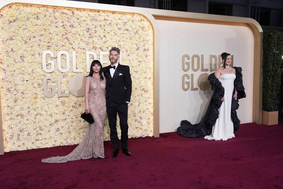 Christina Ricci, from left, Mark Hampton, and Lily Gladstone arrive at the 81st Golden Globe Awards on Sunday, Jan. 7, 2024, at the Beverly Hilton in Beverly Hills, Calif. (Photo by Jordan Strauss/Invision/AP)