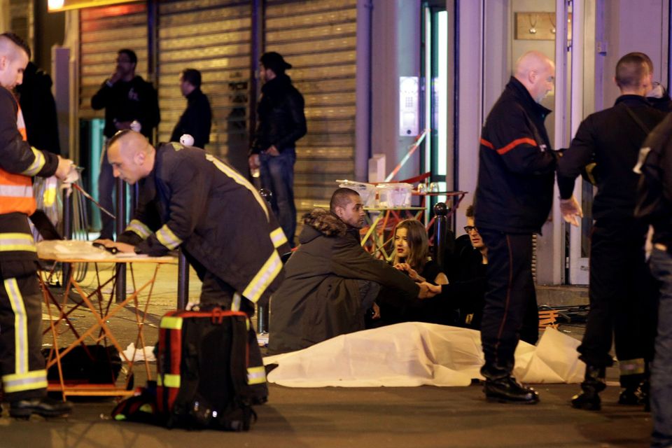 ATTENTION EDITORS - VISUAL COVERAGE OF SCENES OF INJURY OR DEATH  A general view of the scene that shows rescue services personnel working near the covered bodies outside a restaurant following a shooting incident in Paris, France, November 13, 2015.   REUTERS/Philippe Wojazer