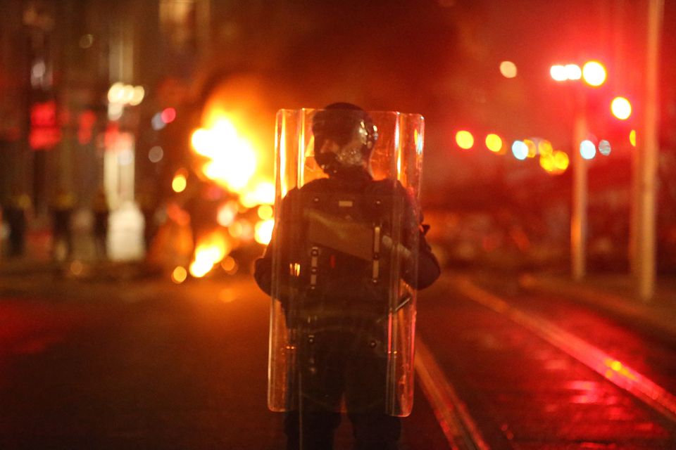 Garda holds a riot shield as protestors are stopped in a street in Dublin,  after Britain's Queen Elizabeth II arrived in the country for a four day  state visit Stock Photo 