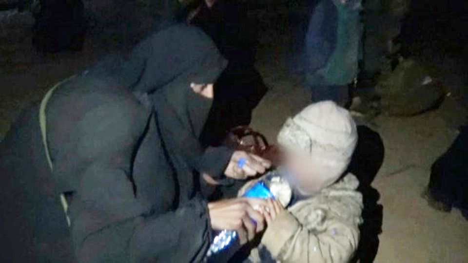 Videograb captured by an ITV cameraman of a woman believed to be Lisa Smith giving water to a young child in a camp in Syria