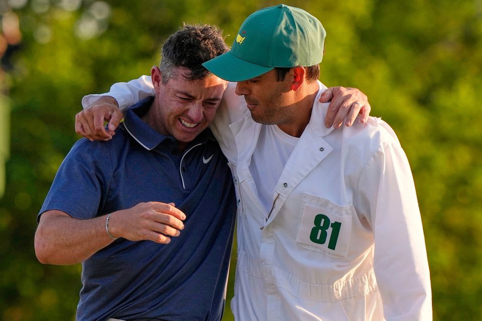 Rory McIlroy hugs caddie Harry Diamond, right, after winning his playoff against Justin Rose at the Masters in Augusta, Ga. (AP Photo/David J. Phillip)