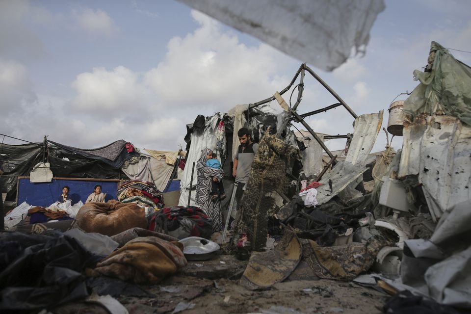 Palestinians inspect their tents destroyed by the Israeli bombardment (Jehad Alshrafi/AP)