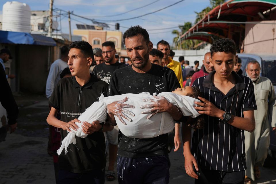 Relatives of Massa Abed (4), who was killed in an Israeli army airstrike on the Gaza Strip, bring her body to hospital in Deir al-Balah. Photo: AP