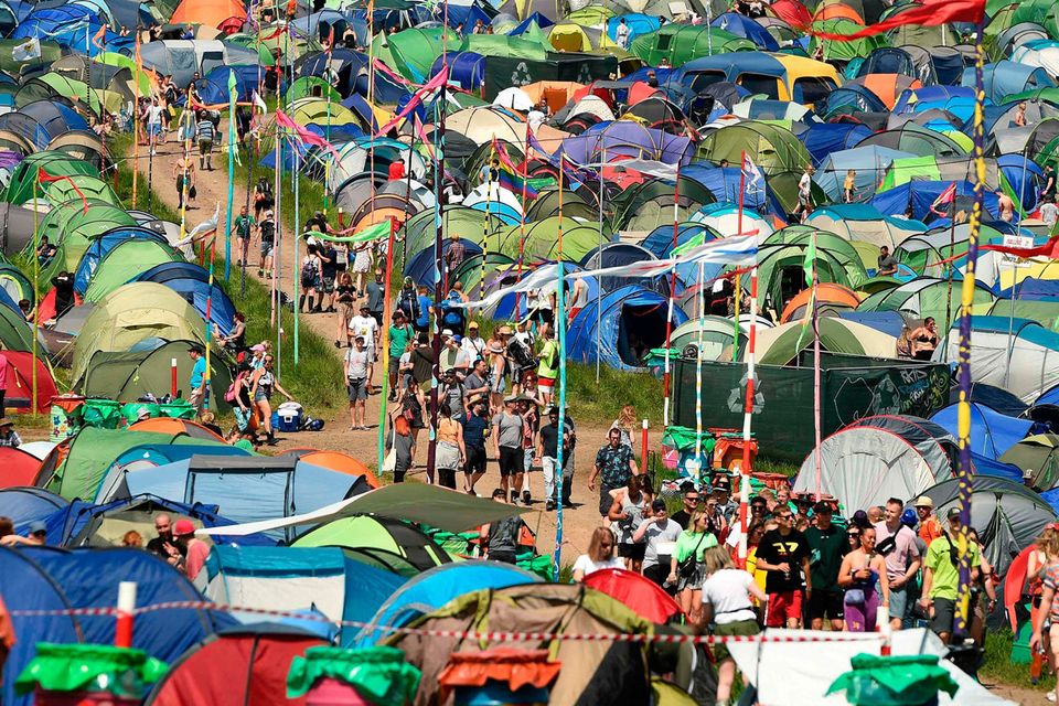 Revellers walk along a pathway surrounded by tents at the Glastonbury Festival of Music and Performing Arts on Worthy Farm near the village of Pilton in Somerset, South West England, on June 26, 2019. (Photo by Oli SCARFF / AFP)OLI SCARFF/AFP/Getty Images