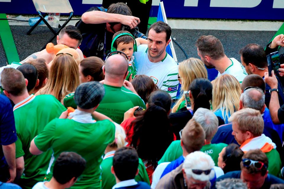 Ireland's John O'Shea holds his son Alfie as he goes over to the fans after the round of 16 match at the Stade de Lyon