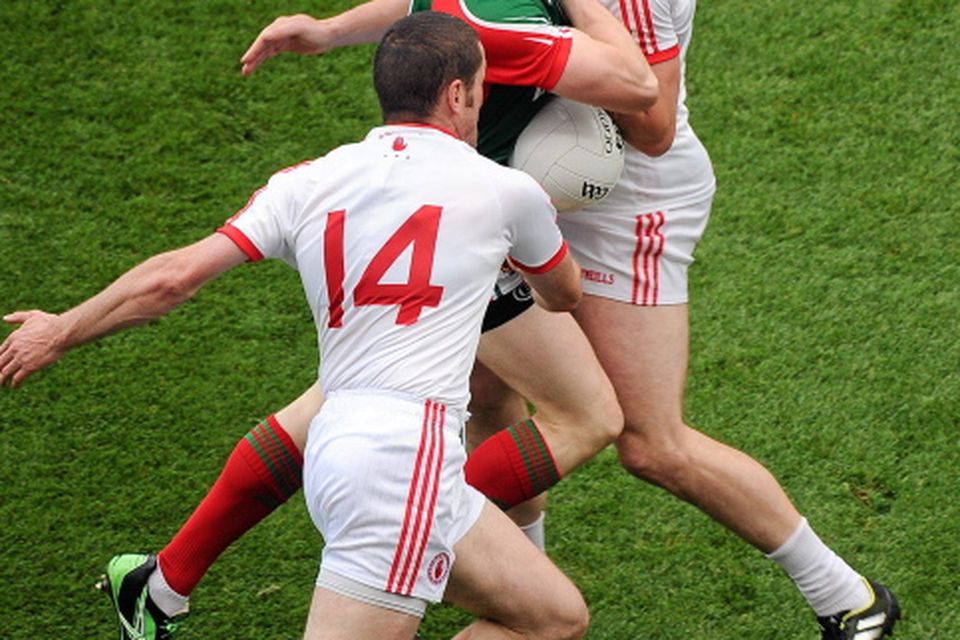 Donal Vaughan, Mayo, in action against Stephen O'Neill, left, and Seán Cavanagh