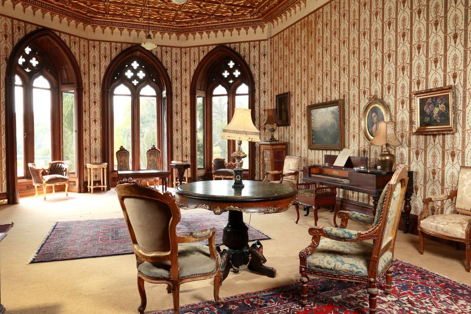 The drawing room with Gothic relief ceiling and soaring arched windows