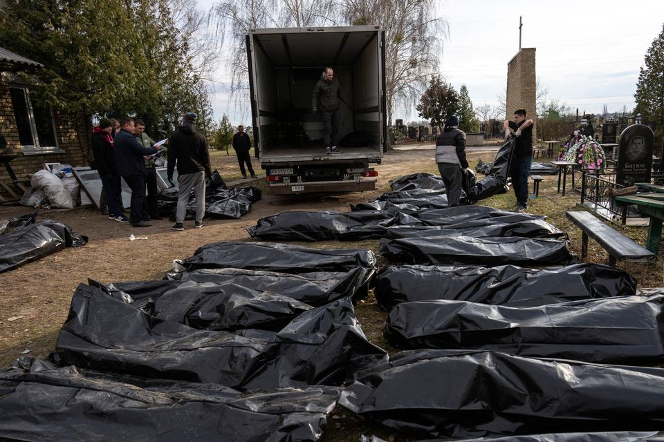 Cemetery workers load the corpses of civilians killed in Bucha into a truck, to be transported to the morgue, on the outskirts of Kyiv, Ukraine. Picture: AP