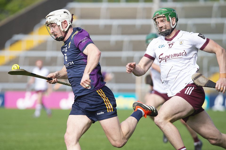 Wexford's Cathal Dunbar racing away from Adrian Tuohey. Photo: Jim Campbell