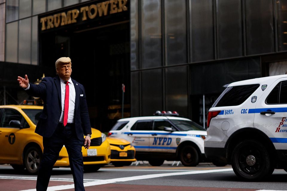 A person wearing a Donald Trump mask walks outside Trump Tower in Manhattan, New York. Photo: Amanda Perobelli/Reuters