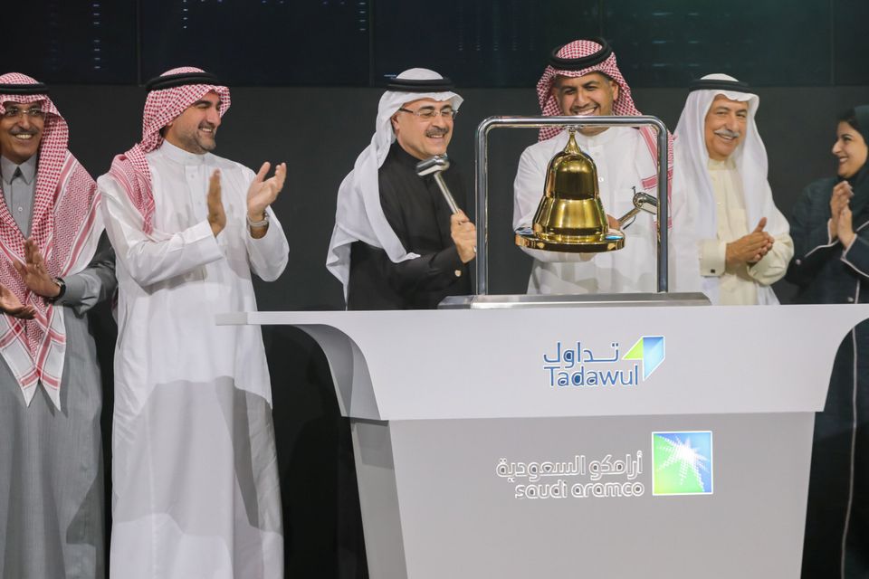 Striking gold: Aramco CEO Amin H Nasser, left, rings the bell during a ceremony marking the debut of its shares in Riyadh