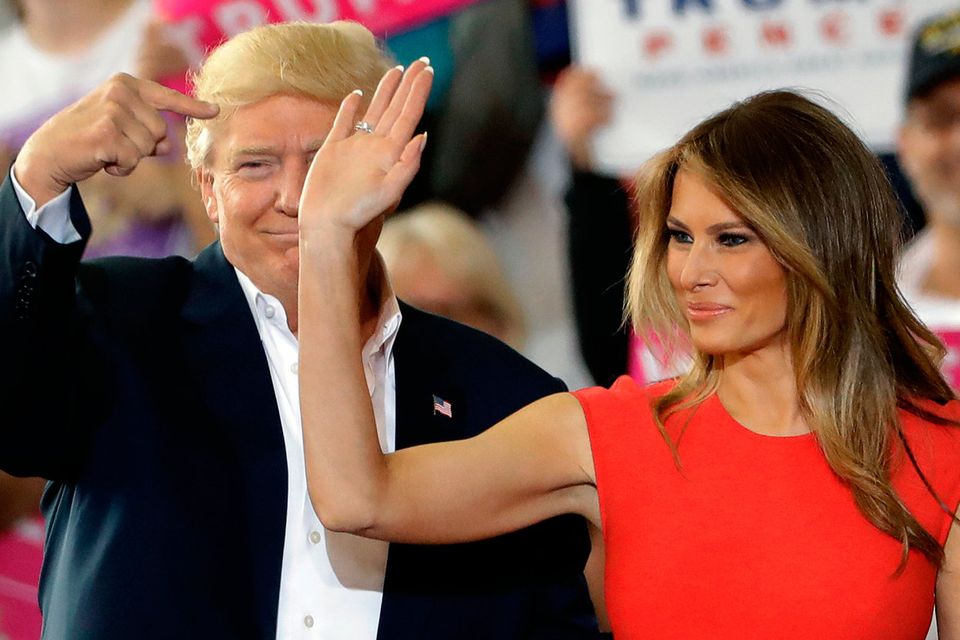 President Donald Trump points to his wife, first lady Melania Trump during a campaign rally Saturday, Feb. 18, 2017, at Orlando-Melbourne International Airport, in Melbourne, Fla. (AP Photo/Chris O'Meara)
