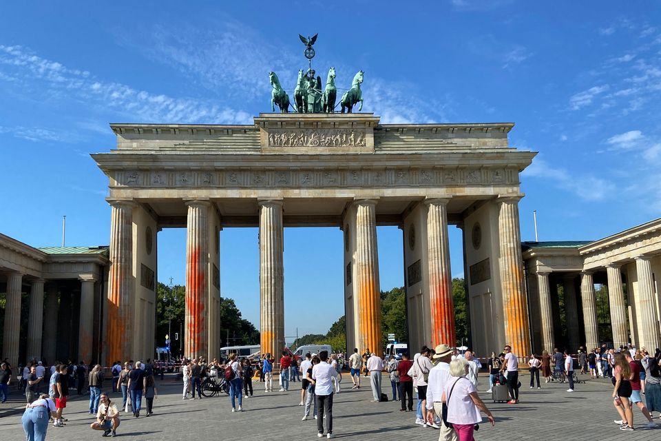 People walk in front of the Brandenburg Gate after Last Generation ("Letzte Generation") climate activists threw paint on the columns of the Brandenburg Gate in Berlin. Photo: Swantje Stei