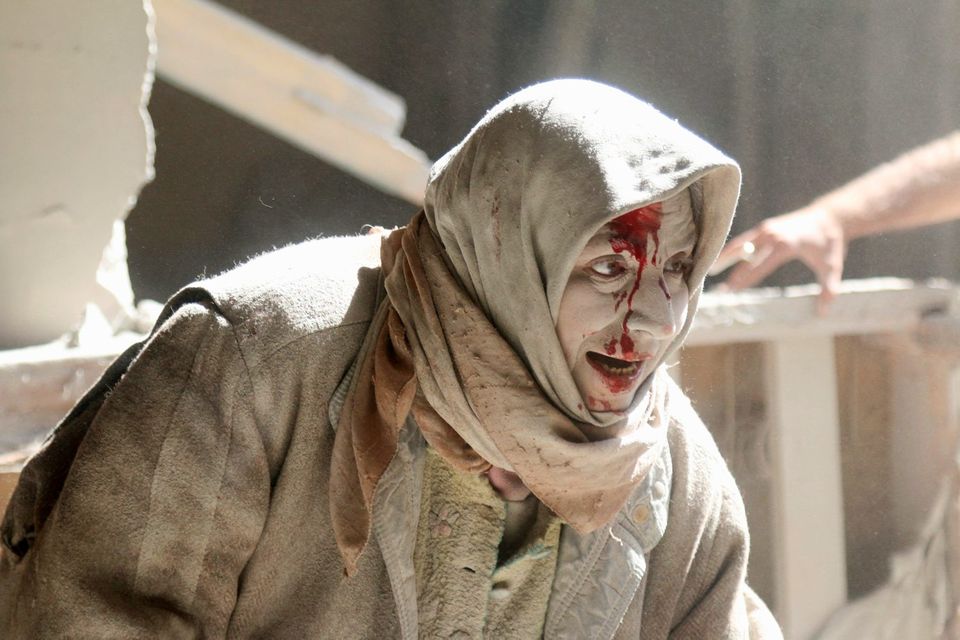 An injured woman reacts at a site hit by airstrikes in the rebel held area of Old Aleppo, Syria. Photo: Reuters