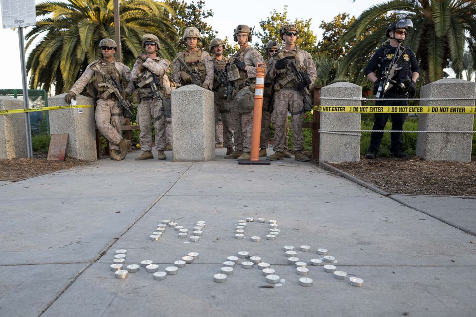 US marines soldiers seen behind candles configured in a 'No War' statement outside of the Federal Building in downtown Los Angeles during the 'No War On Iran' protest. Photo: Getty