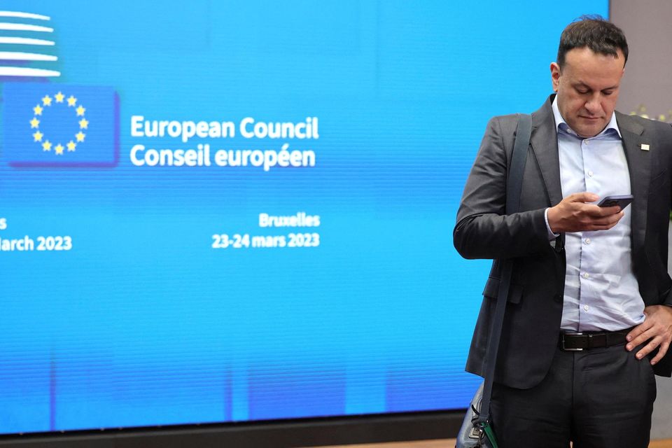 Taoiseach Leo Varadkar checks his phone prior to leaving the building after an EU summit at the European Council building in Brussels. Photo: Reuters