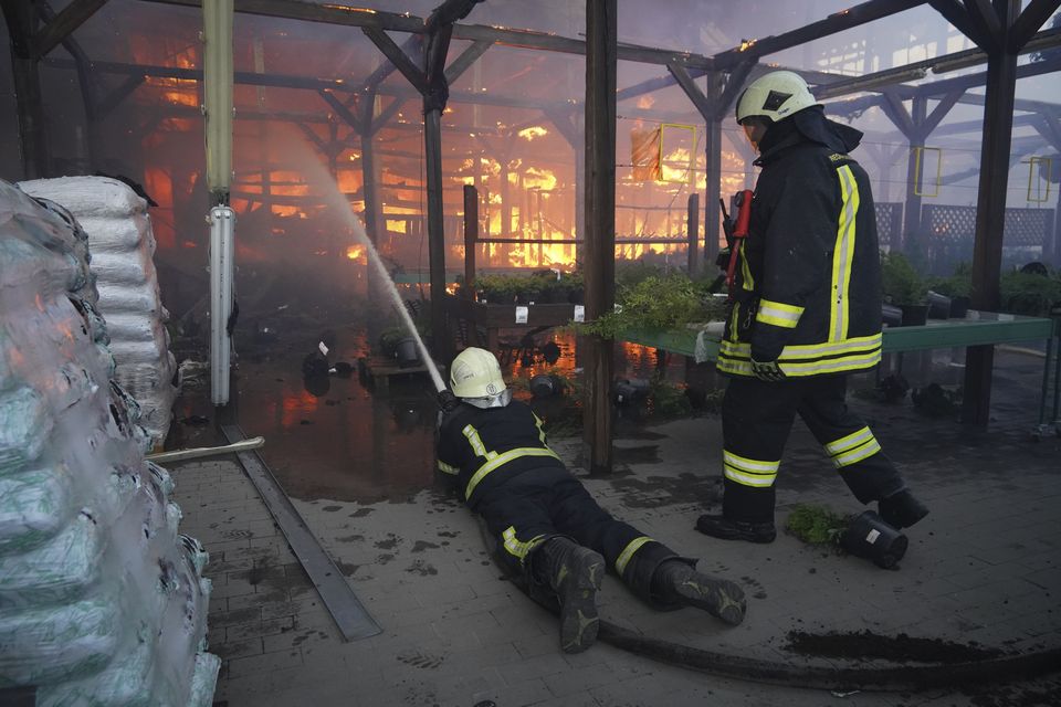 Firefighters put out a fire after two guided bombs hit a large construction supplies store in Kharkiv (Andrii Marienko/AP)
